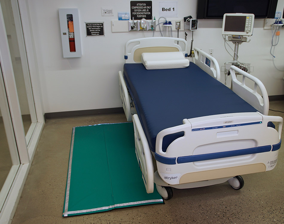 Hospital bed with custom foam mattress and floor mat.